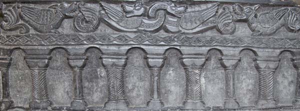 West side. Despite the teaching in the Church that the earth was a sphere, on the west side of the marble the sculptors of Tournai prefer to show the world as flat, resting on a series of pillars and arches and above on the surface of the ground mystical beasts which represented the real-life creatures from the reptiles to the birds, which God had created.