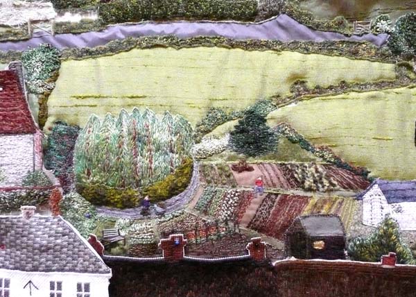 Fields, roads, hedges and bushes (as in the depiction of the Allotments, above) were embroidered either in situ directly on the calico, or using the same techniques as for the houses, or using materials with stitches applied for extra interest. 