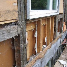 Insulation being installed below the north window of the second floor