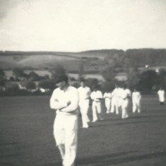 Cricket team coming off field, John Berry leading.