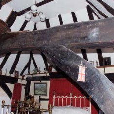 Upstairs room in which the construction of the roof beams has been exposed, showing the sans purlin framework.