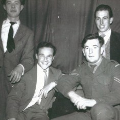 Four young men, one in uniform
