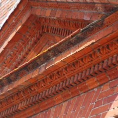 The intricate brickwork of the pediment over the front door.