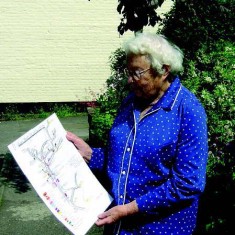 Margery Lambert, photographed in 2007, with her map of the shops and trades in East Meon in the 1920s