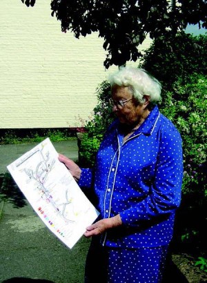 Margery Lambert, photographed in 2007, with her map of the shops and trades in East Meon in the 1920s