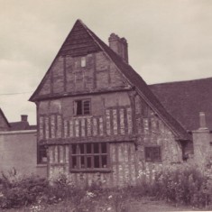Tudor House from the south, showing the overgrown garden. The back of the shop extension is visible on the left the laundry outbuilding on the right.