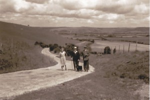 Threesome walking up Leydene hill, East Meon in background.