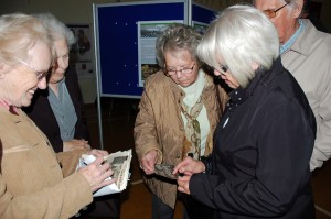 Ladies discussing the photos they have brought for archiving.
