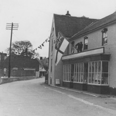 Man erecting Royal Navy Ensign on Country Store.