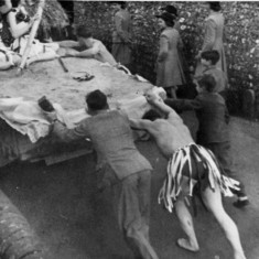 Men pushing Berry family lorry during fancy dress parade.
