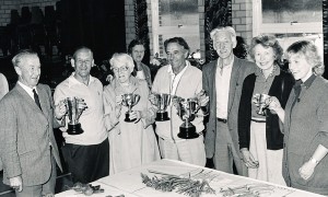 Garden Club Annual Show in Village hall, cup winners. On left, Admiral Dennis Mason, on right, Paddy Mason and Jane Atkinson. 