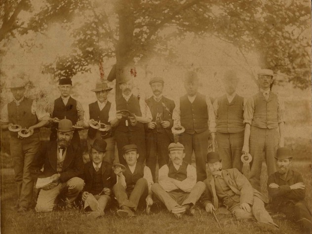 A very early photograph showing men holding what look like quoits