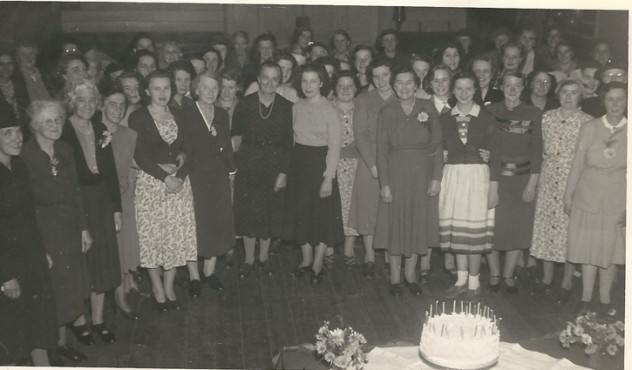 Large gathering at the old Village Institute. Marion Lambert, Bridget's mother, is in the crowd .