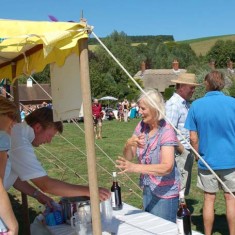 Pimms stall on The Green. Chris Gieves serves, Caroline Coe purchases. 
