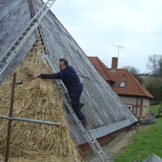 Lyle Morgan thatching corner of barn Lyle Morgan thatching corner of barn