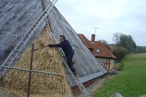 Lyle Morgan thatching corner of barn
