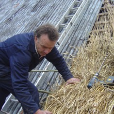 Thatching CU Lyle Morgan, master thatcher who has done much recent work in the village.