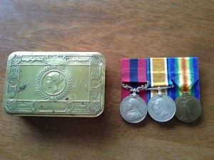 Edward Bone's medals and the tin in which they have been kept.