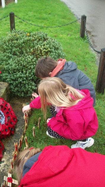 Two planting crosses Two pupils placing crosses at War Memorial