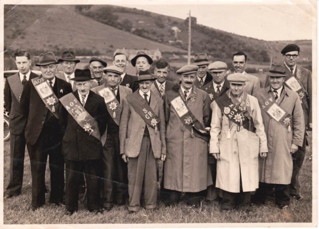 C 1950, Court of Meon Valley Ancient Order of Foresters, George, (Shaver), Cook, (my Fathers Brother), is front row with the lighter coloured Coat. My father, Jack Cook, is looking over his brothers right shoulder. Extreme right, Jack Appleby.  Back row  in front of School, Fred Gibbs and Jack Porter. Herbie Goddard, back row to the left.