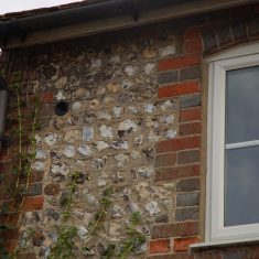The end of a bottle embedded in the wall of the Cottages, from which they took their name.