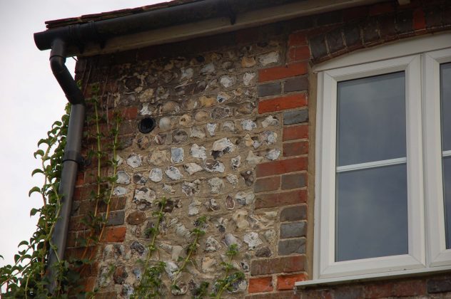 The end of a bottle embedded in the wall of the Cottages, from which they took their name.