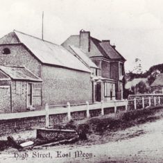 East Meon High Street looking east, probably early 20th century. The small hut on the left was a kiosk where a fishmonger from Winchester sold his wares once a week, then the barn of what was Coles' dairy, then the Gaite House where Coles operated his shop, then Glenthorne House. Tilbury's shop, later Adams and then Savage & Parsons is on the other side of the street.