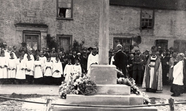 This shows the dedication of the new War Memorial commissioned by Rev. Thomas Heywood Masters and designed by Ninian Comper. y 11923, Masters was no longer vicar of East Meon and it is not known whether the clergyman to the left of the memorial is Masters or his successor Rev Crawley.