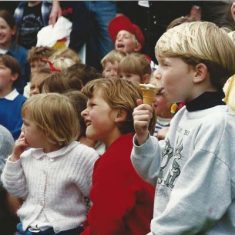 Kids watching arena display, sucking lollies